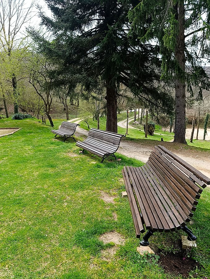 Bancs de fusta al jardí, al costat del camí que travessa la finca