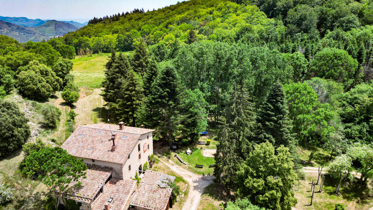 Mas Vilarmau amb la vall i les muntanyes del Montseny al fons, vista de dron